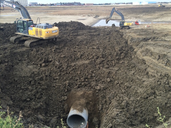 Construction crews complete work on the three inlets and one outlet for the stormwater pond. The inlets and outlets regulate the water level. 