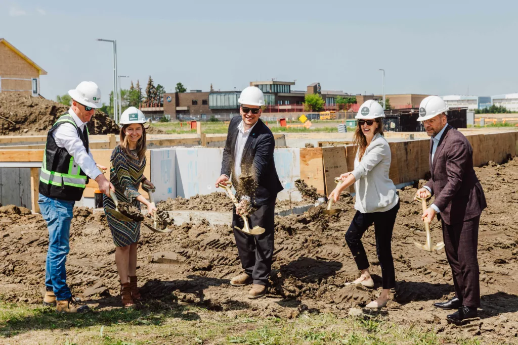 Group throwing dirt to signify the start of construction