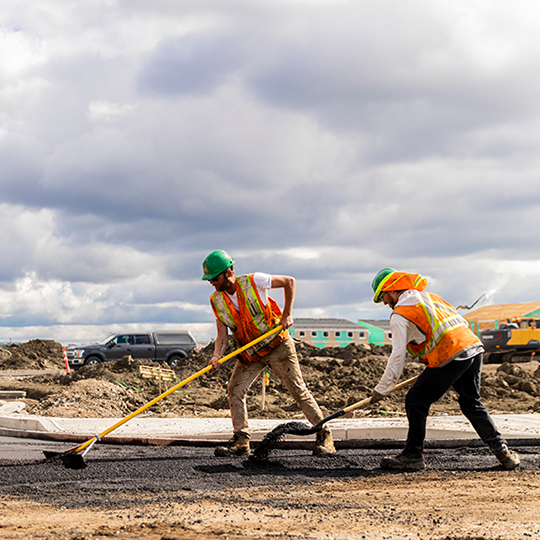 Construction workers install asphalt