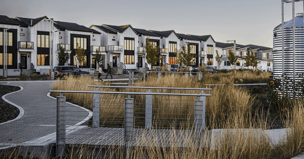 White rowhouses with sustainable landscaping in foreground